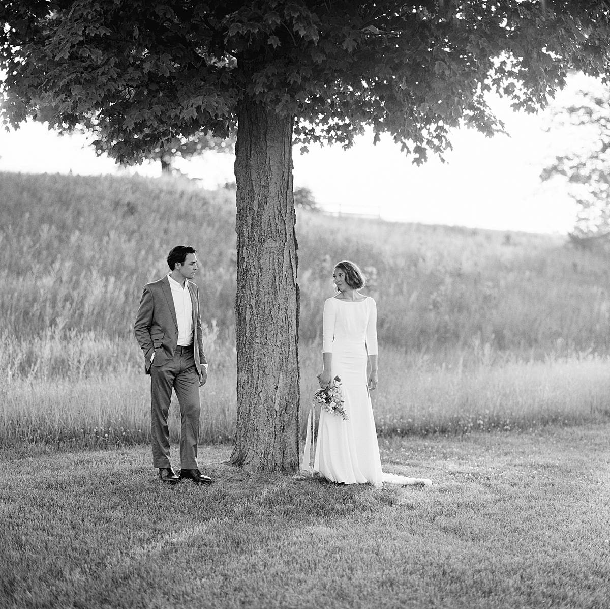 black and white film wedding portrait on hasselblad with bride and groom standing beneath tree at felt mansion